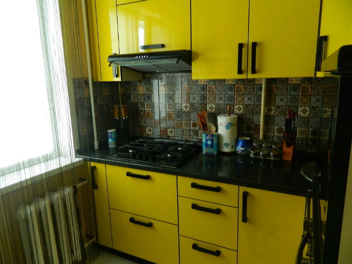 Яркая кухня в желто-черных оттенках.