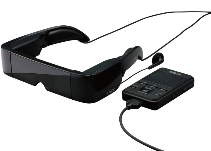Компания Epson анонсировала видео-очки Moverio BT-100, особенностью которых является их прозрачность, что позволяет одновременно смотреть видео и быть в курсе происходящего вокруг. Очки оснащены оснащены двумя мини-экранами с разрешением 960x540.