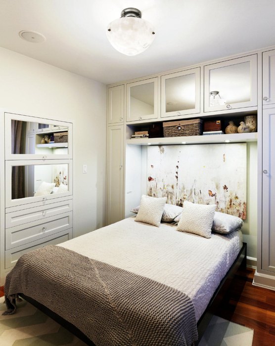 В спальне роль окон выполняют зеркала и подсвеченные прозрачные дверки шкафчиков над кроватью