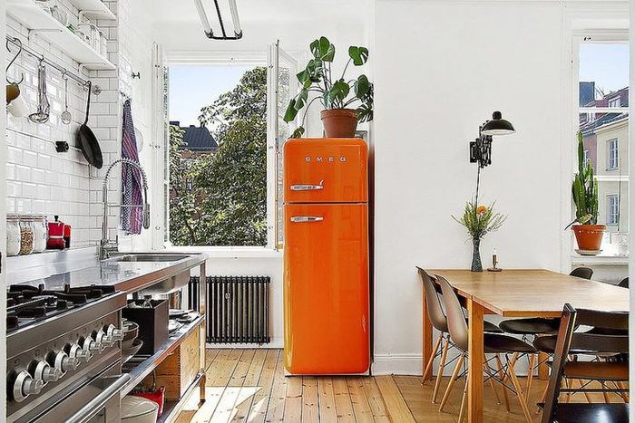 Рыжий холодильник вносит в интерьер кухни нотки тепла