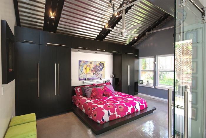 Спальня в черно-розовых тонах с необычным гофрированным потолком, который отлично дополняет общий интерьер.