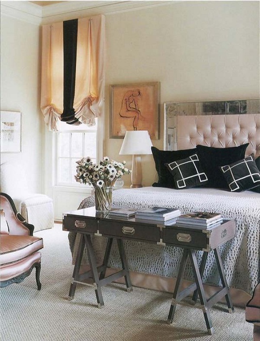 Интересный интерьер в спальне дополнен столиком у изножья кровати, который украшен вазой с цветами.