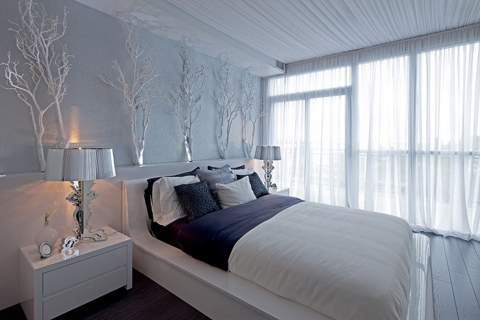 Спальня в светлых тонах удачно дополнена декорированными ветками, которые освежают общую обстановку.
