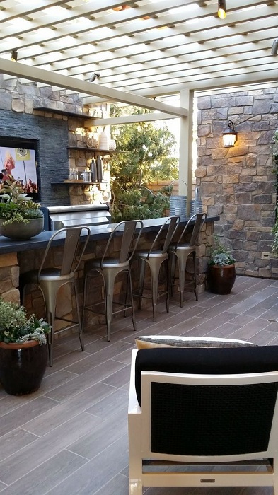 Открытая бар-зона защищена белой беседкой. Барные стулья в промышленном стиле подчеркивают пространство зоны отдыха.