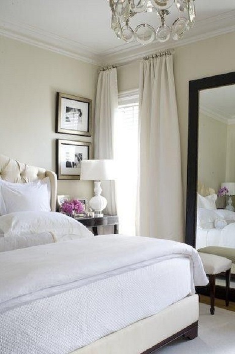 Простая и светлая атмосфера в спальной создана благодаря светлым томам и интересному зеркалу.