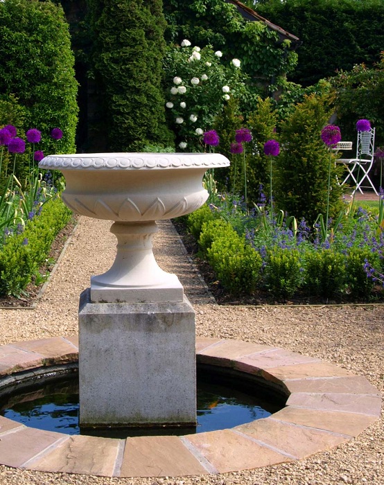 Возможно сделать простой и красивый фонтан в саду с множеством различных зеленых растений и оформить его белыми камнями.