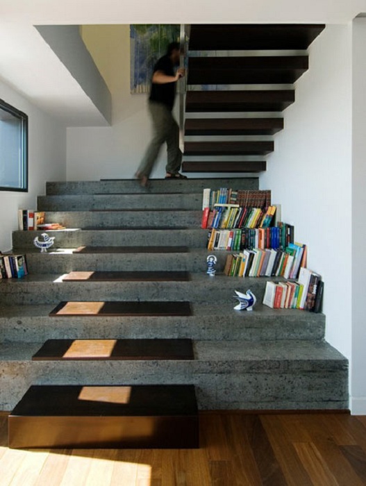 Очень широкая каменная лестница с деревянными ступенями на вершине совпадает с плавающей деревянной лестницей выше, имеет достаточно места для хранения книг по бокам.