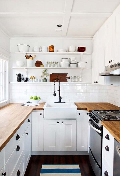 Белая кухня с деревянными столешницами - отличный вариант для дизайна кухонного пространства.