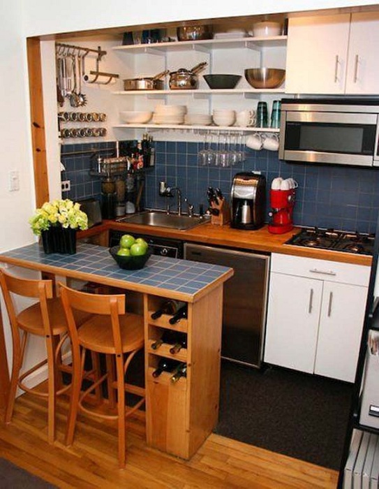 Прекрасный синий кухонный гарнитур, который дополнен деревянными элементами.