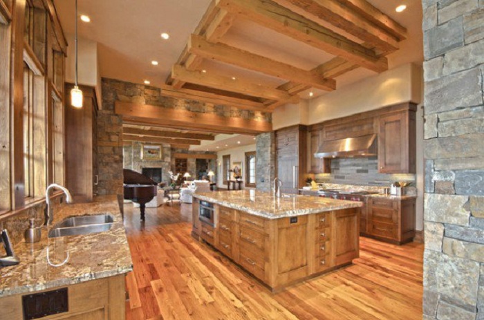 Интересное оформление кухни в коричневых тонах дополнено деревянным потолком.