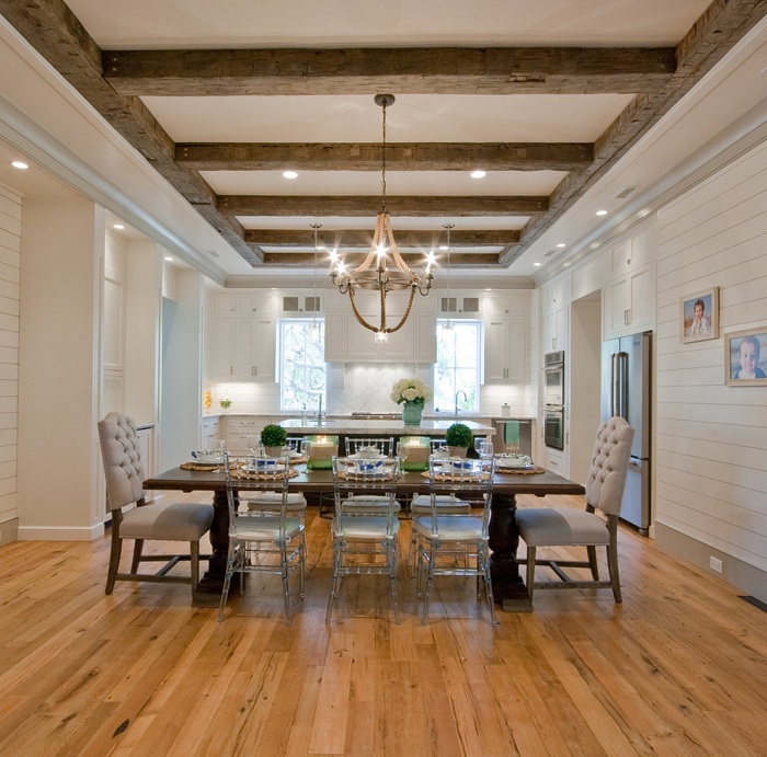 Симпатичный и светлый интерьер гостиной с деревянными балками на потолке.