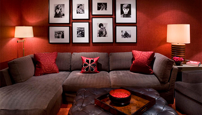 Прекрасная комната красного цвета с диваном шоколадного цвета.