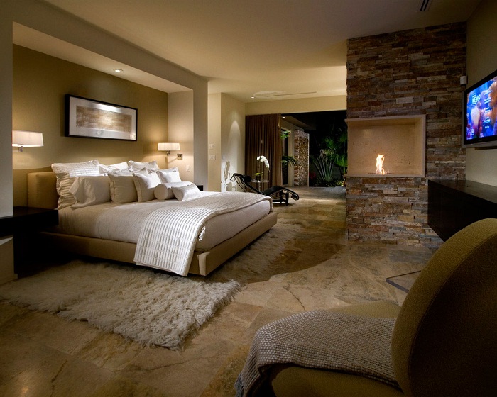 Оригинальный интерьер спальной украшен благодаря камину размещенному в ней.