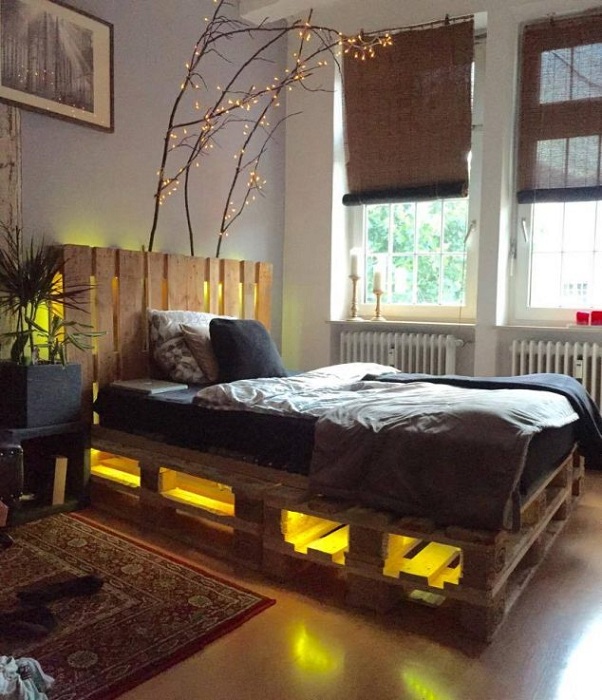 Отличная домашняя атмосфера создана в спальной благодаря кровати выполненной из паллет.