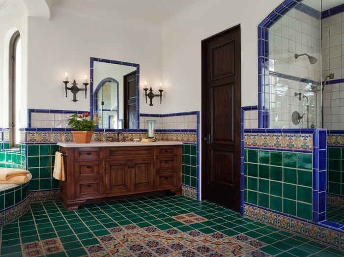 Ванная комната декорирована плиткой в зеленом цвете.