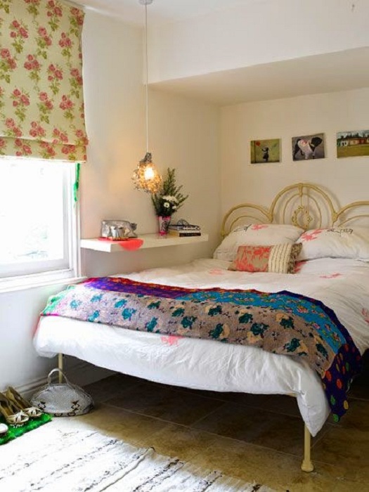 Яркий интерьер спальни преображен с помощью практичной полочки у кровати.