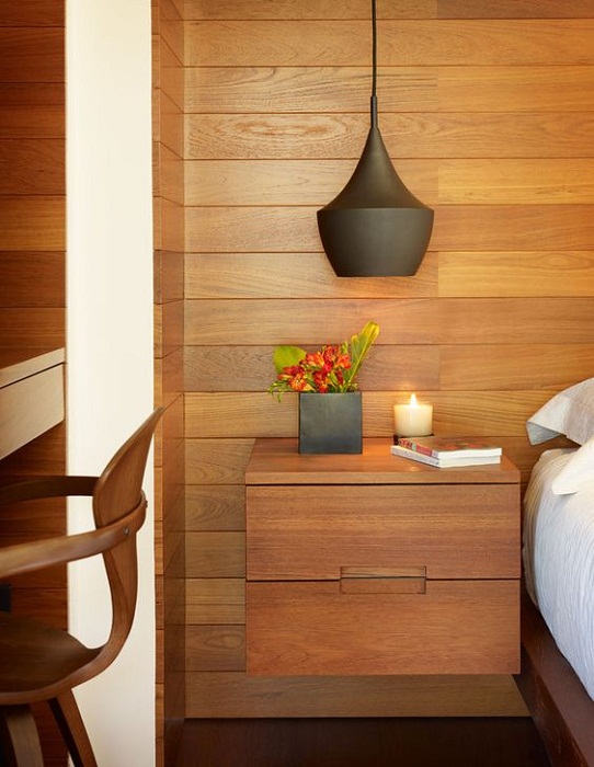 Интересный вариант декорировать прикроватное пространство с помощью деревянной ниши с двумя ящиками.