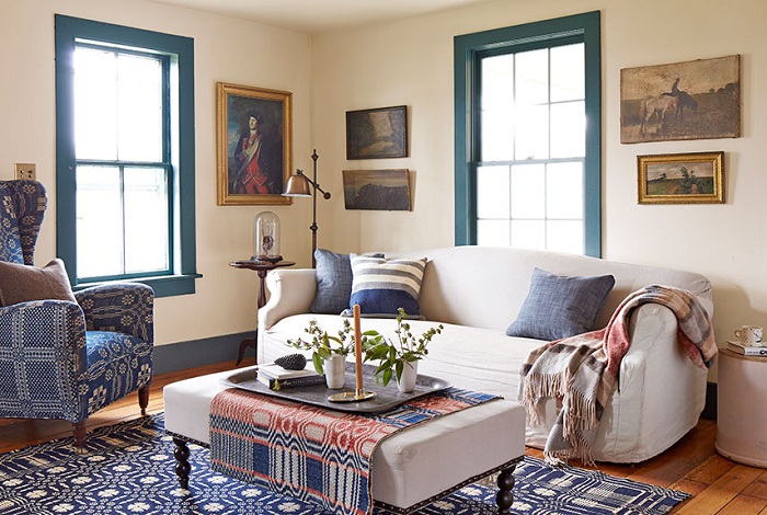 Интересная гостиная с синими окнами, украшена картинами.
