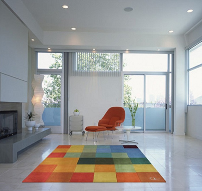 Белоснежная комната подчеркивает свой цвет и индивидуальность при помощи неординарного ковра с яркими квадратами.