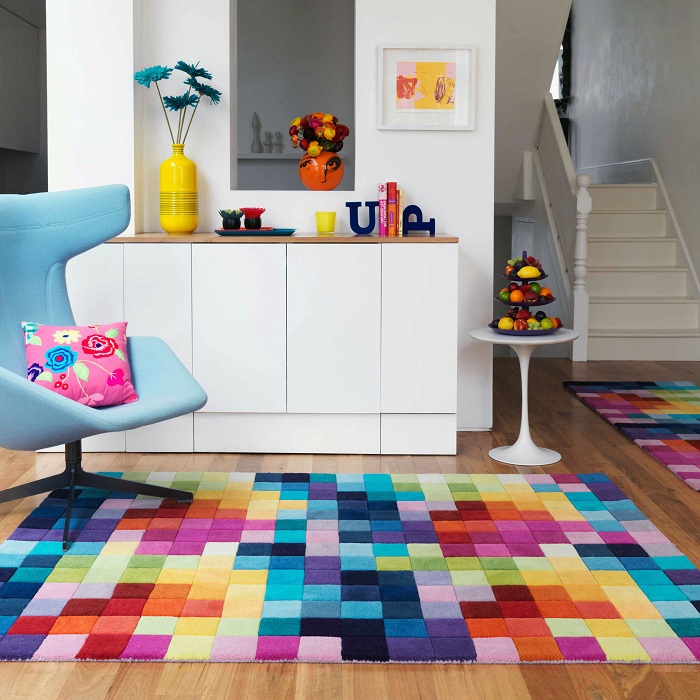 Отличное положительное настроение в комнате подчеркивает яркий коврик на полу и яркие мелкие детали интерьера.