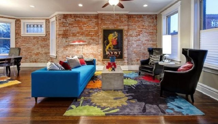 Кирпичная кладка на стене дополнена яркими цветами в интерьере для прекрасной и гармоничной обстановки в комнате.