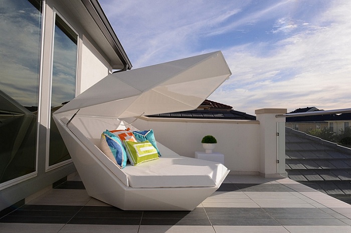 Белый диван интересной формы станет отличным дополнением к дизайну пространства на открытом воздухе.
