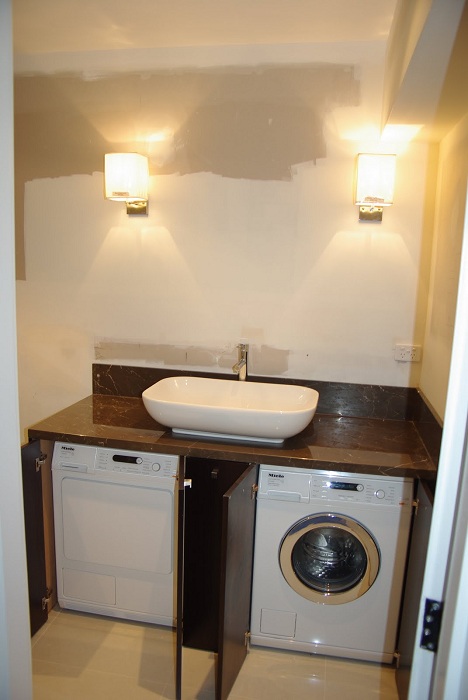 Интересный вариант - размещение стиральных машин под раковиной, что позволит сэкономить пространство в комнате.