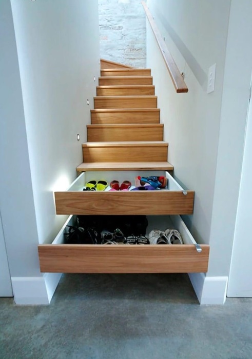 Выдвижные ящики для обуви и других мелких предметов, вмонтированные под лестничными ступеньками. 