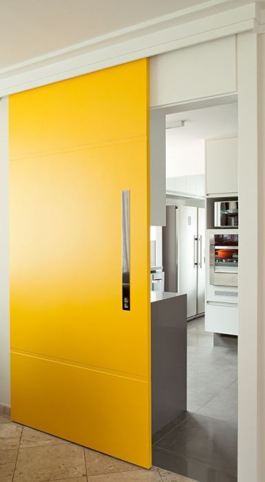 Ярко-желтые раздвижные межкомнатные двери, которые акцентным пятном выделяются на фоне светлого интерьера. 