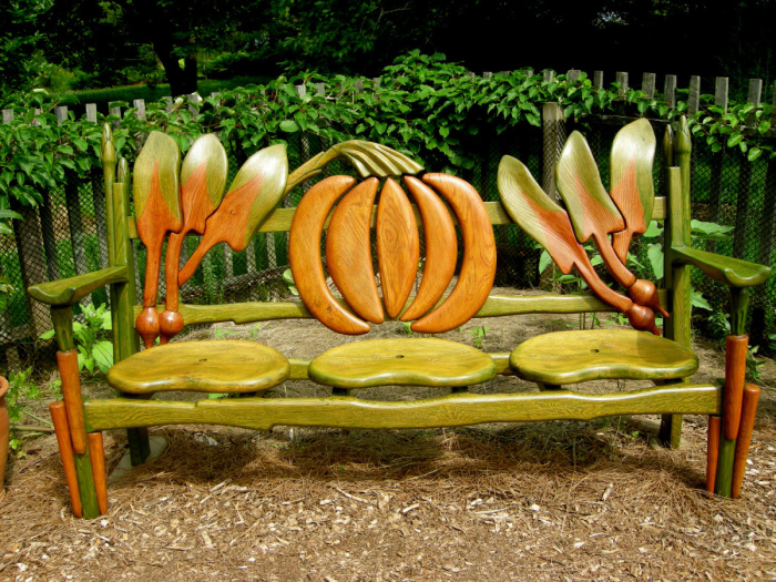 Деревянная скамейка очень необычной формы, которая впишется в любой садовый участок. 
