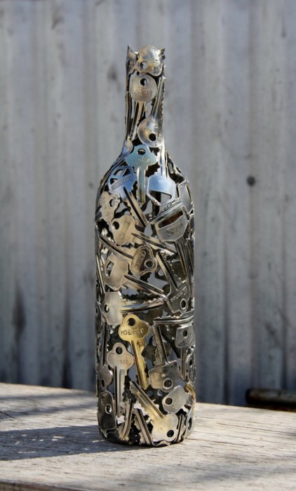 Оригинальная отделка ключами прозрачной винной бутылки.  