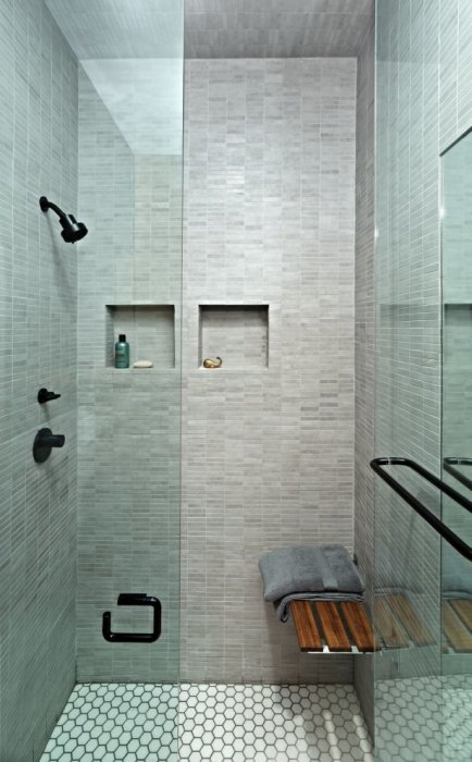 Небольшая ванная комната с душевой кабинкой с прозрачными стенами и керамической плиткой. 
