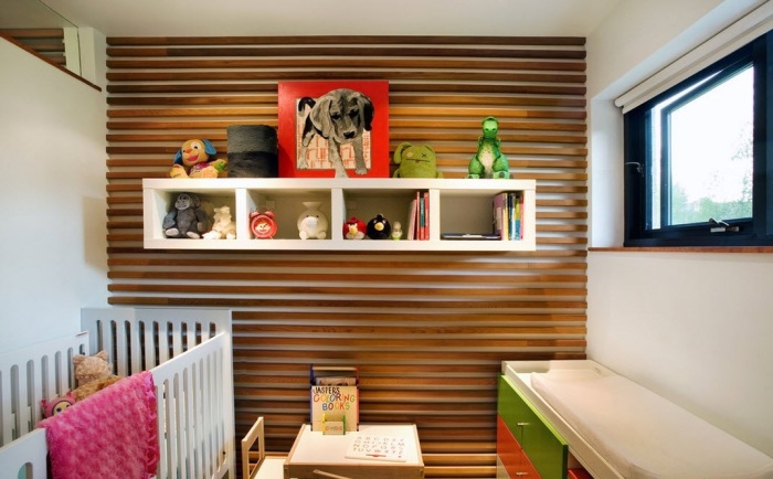 Деревянные панели на стене позволяют зрительно увеличить пространство детской комнаты. 