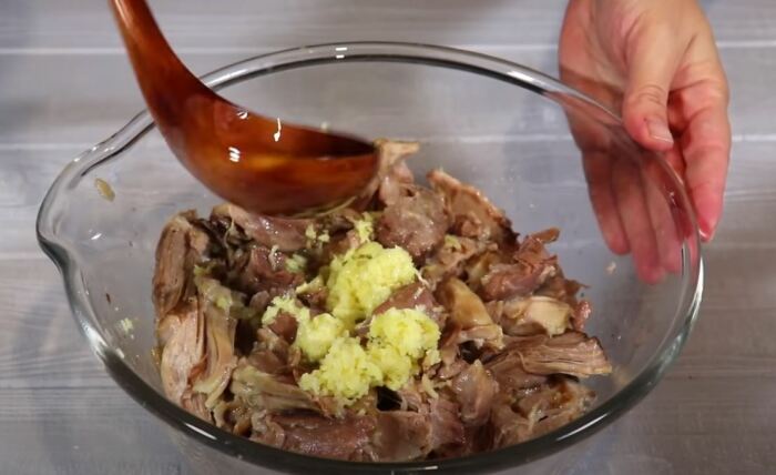 перемешиваем мясо с бульоном и чесноком. /Фото: youtube.com.