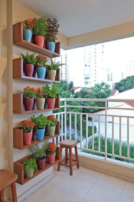 Не загромождайте стены шкафами на балконе, задекорируйте стену из замечательной композиции цветков в горшках.