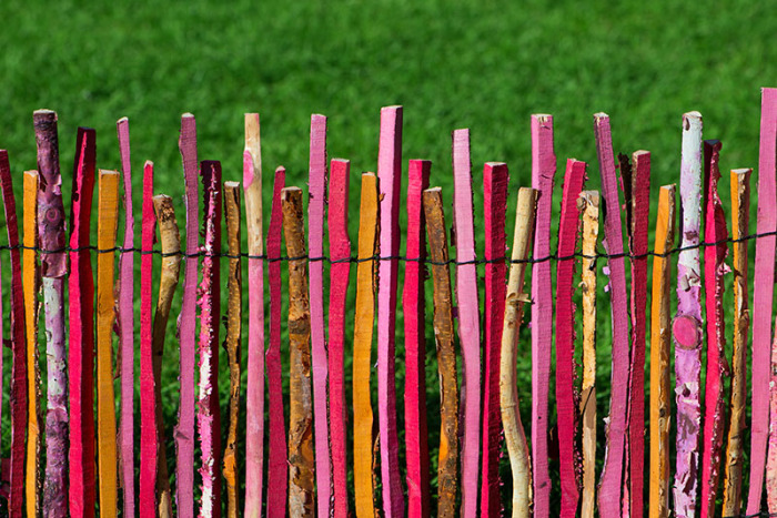 Симпатичный разноцветный забор из деревянных палок. 