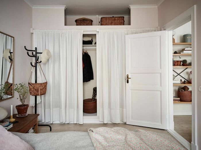 Еще одна небольшая гардеробная, расположенная в нише и прикрытая шторами. /Фото: i.pinimg.com
