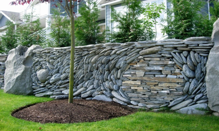 Играя с цветом, размером и кладкой камней можно создать настоящий забор-картину. /Фото: villagebookstoremn.com
