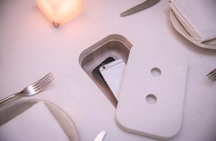 Даже для элитного ресторана Sara (Торонто) разработали специальные обеденные столы, где есть специальные ячейки для мобильных телефонов. | Фото: blogto.com.