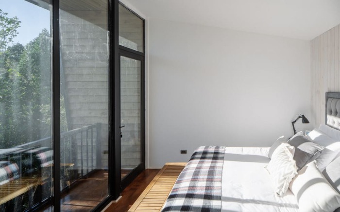 Родительская спальня с индивидуальной ванной комнатой и балконом расположены на втором уровне (Un Patio House, Молко). | Фото: dezeen.com.