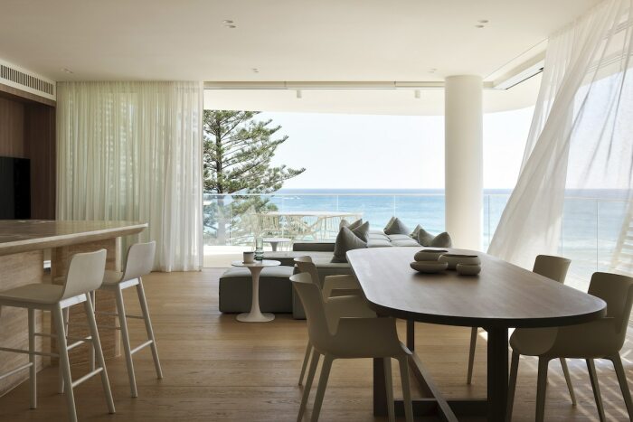 Просторная гостиная и столовая расположены у панорамного окна, откуда отрывается захватывающий вид на побережье и пляж (Norfolk Burleigh Heads, Квинсленд). | Фото: mymodernmet.com.