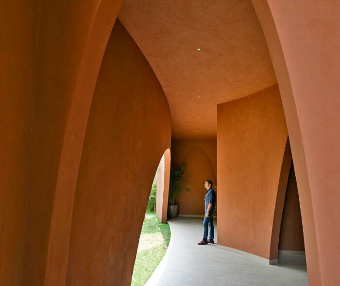 Из общего пространства предусмотрен выход во внутренний двор к зонам отдыха, спрятанным за скульптурной стеной и арками (Mirai House of Arches, Индия). | Фото: label-magazine.com.