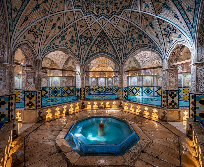 В центре прекрасно оформленного зала установлен бассейн/пруд с фонтаном, журчание воды которого поддерживает умиротворяющую обстановку (Qasemi Bathhouse, Кашан). | Фото: islamichistoryandtravel.com.