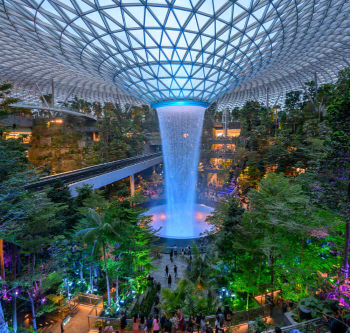 В вечернее время устраивают световое шоу, где потоки воды играют главенствующую роль (Rain Vortex, Jewel Changi Airport). | Фото: airport-technology.com.