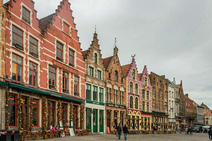 Рыночная площадь, является основным центром празднования Рождества с ледовым катком под открытым небом и яркими пряничными домиками (Брюгге, Бельгия). | Фото: flyingforktales.com.