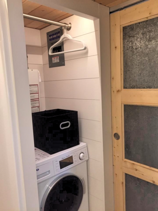 Между кухней и ванной нашлось местечко для стиральной машины и вешалки (The Elsa tiny home). | Фото: © olivenesttinyhomes.