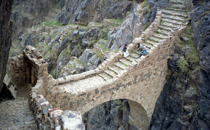 Простираясь через ущелье глубиной 91 метр между двумя вершинами каньона, мост Шехара до сих пор широко используется гражданами, живущими в горных деревнях (Амран, Йемен). | Фото: ancient-origins.net.