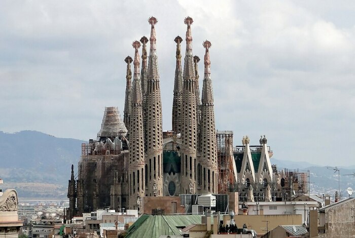 Культовая базилика La Sagrada Familia привлекает миллионы посетителей в Барселону (Испания). | Фото: city-sightseeing.com.