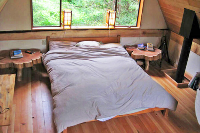 Спальная комната может похвастаться интересной мебелью и натуральной отделкой А-образной структуры потолка (Japanese Forest House, США). | Фото: travelpluss.wordpress.com.