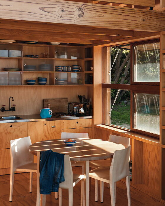 Кухня-столовая находится в центре нижнего уровня, но эти зоны не лишены естественного освещения (The Hut on Sleds, Новая Зеландия). | Фото: worldarchitecture.org.